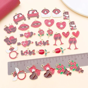 Flat lay of heart and love themed enamel charms for DIY jewelry with measurement ruler