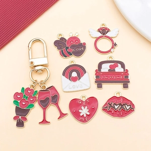 Flat lay of red Valentine's Day alloy charms with wine glass, ring, and heart designs