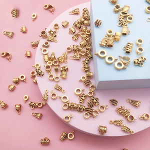 Detailed view of antique gold bails and cylindrical beads for DIY bracelet jewelry making