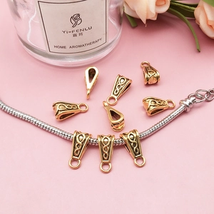 Detailed close-up of antique gold bail bead with Celtic patterns on a silver chain