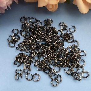 Makroaufnahme von gun-schwarzen Biegeringen für DIY-Schmuck auf hellblauem Grund