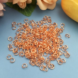 Nahaufnahme von roségoldenen Biegeringen für DIY-Schmuck auf hellblauem Hintergrund