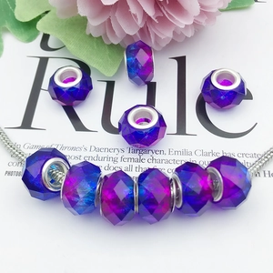 Macro detail of multifaceted purple and blue gradient star beads on silver snake chain
