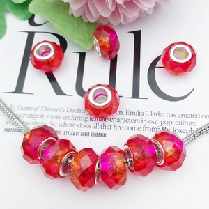 Macro shot of red faceted crystal beads with silver cores on a metal snake chain
