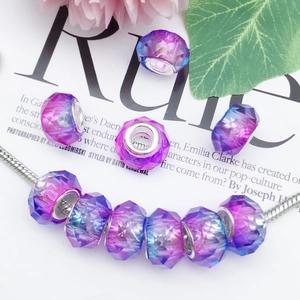 Macro detail of faceted gradient purple and blue large hole beads on a silver bracelet