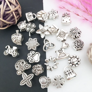 Vue détaillée de breloques en alliage d'argent antique avec motifs patte de chien et trèfle