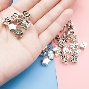 Detailed view of silver alloy DIY charm beads featuring stars, crowns and engraved motifs
