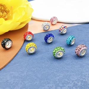Vista macro de cuentas de arcilla con cristales incrustados para pulseras de DIY
