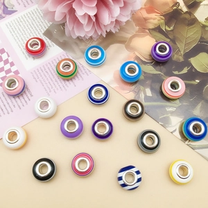 Macro shot of colorful striped resin beads with silver metal cores for DIY jewelry making