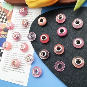 Detalle macro de cuentas rosas con agujeros grandes y núcleos plateados para DIY
