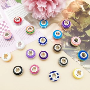 Close-up of colorful striped resin beads with metal core for DIY bracelet making
