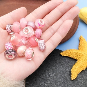 Detalle de cuentas de vidrio rosa con motivos florales y núcleo de plata para joyas