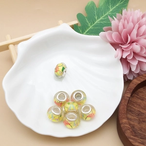Detail von gelben Blumenperlen aus Acryl mit rotem Muster für DIY-Armbandherstellung