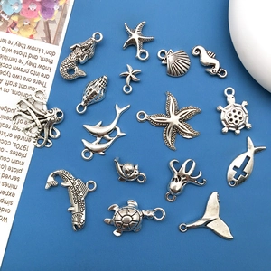 Macro view of fifteen antique silver marine charms including mermaid and seahorse shapes