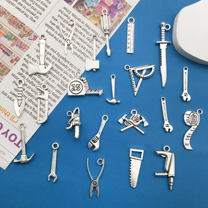 Set of vintage silver alloy tool pendants including saws and rulers for DIY jewelry making