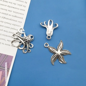Macro shot of vintage silver starfish and octopus charms for DIY jewelry making