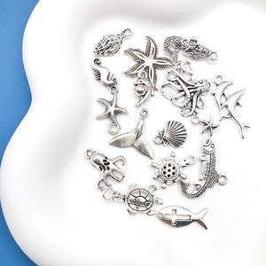 Macro shot of assorted ocean themed silver alloy charms including seahorse and starfish