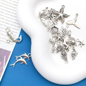 Macro detail of antique silver ocean charms including starfish and turtles for DIY jewelry