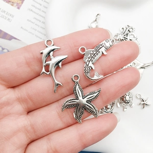 Detailed macro view of vintage silver marine animal charms for DIY jewelry making