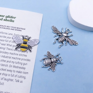 Detail van bijenhangers van emaille en antiek zilver voor het maken van DIY sieraden