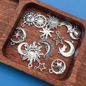 Détail macro de pendentifs soleil, lune et étoiles sur un plateau en bois rustique