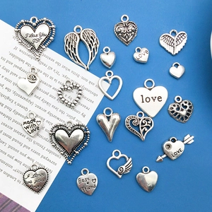 Close-up of vintage silver alloy heart and wing charms for DIY jewelry making