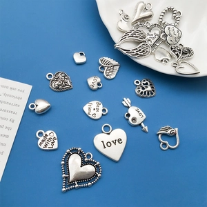 Macro shot of assorted silver heart charms and wing pendants for necklace and jewelry making