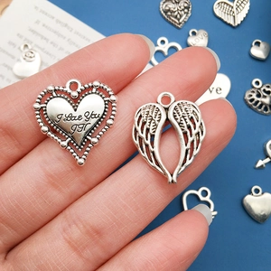 Detail of I Love You engraved heart charm and angel wing pendant for DIY jewelry