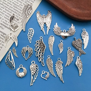 Pendentifs ailes et cœurs en alliage argenté antique pour bijoux DIY sur fond bleu
