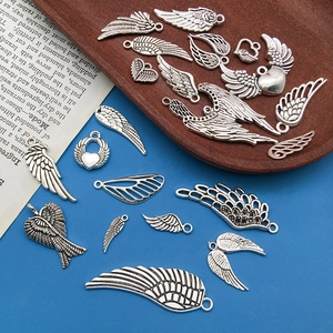 Vue détaillée de breloques ailes d'ange en alliage argenté avec textures de plumes pour bijoux