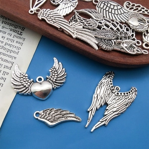 Vue macro de pendentifs ailes d'ange en alliage argent vintage avec détails cœur et plumes