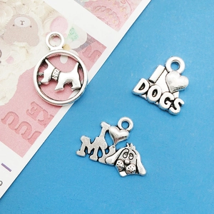 Detailed view of three vintage silver alloy dog charms including I Heart Dogs engraving