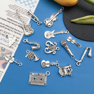 Detailed collection of vintage silver musical instrument alloy charms on blue surface