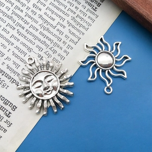 Gros plan de pendentifs soleil vintage en argent avec relief pour création de bijoux