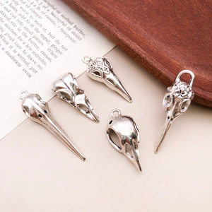 Detailed close-up of five vintage silver bird skull pendants with gothic alloy textures