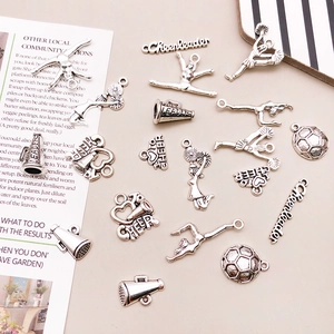 Détails macro des breloques pom-pom girl et football en argent antique pour bijoux DIY