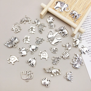 Dettagli di ciondoli a forma di elefante in argento vintage su un vassoio di legno
