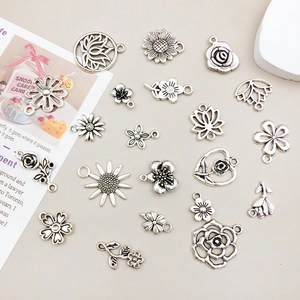 Detail of vintage silver flower pendants and plant charms for DIY jewelry making