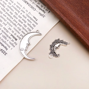 Makroaufnahme von Vintage Silber Mond- und Sternanhängern auf Holz für Schmuck DIY-Projekte
