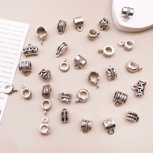 Plano cenital de cuentas espaciadoras y dijes de plata antigua para joyería artesanal