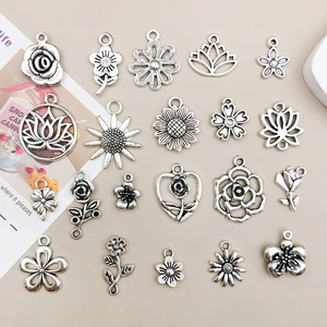 Detailed flat lay of 20 antique silver floral alloy charms for DIY jewelry making