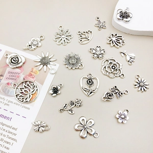 Detail of vintage silver flower pendants and alloy charms for DIY jewelry crafting