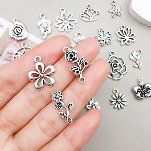 Detailed close-up of antique silver flower charms for DIY handmade jewelry crafting