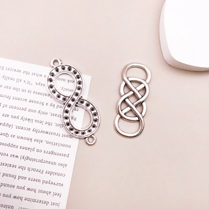 Detailed view of silver infinity knot charms and connectors for DIY jewelry making