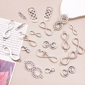 Detailed view of infinity symbol alloy charms and Love pendants for DIY jewelry making