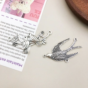 Detalle de dijes de pájaros y golondrinas en plata antigua para creación de joyas DIY