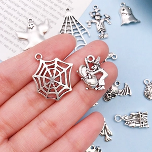 Gedetailleerde macro-opname van Halloween-bedeltjes met spinnenweb en heks voor DIY-sieraden