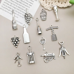 Macro view of vintage silver alloy wine bottle and grape pendants for DIY jewelry making