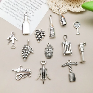 Macro detail of antique silver wine bottle and grape pendants for DIY jewelry making