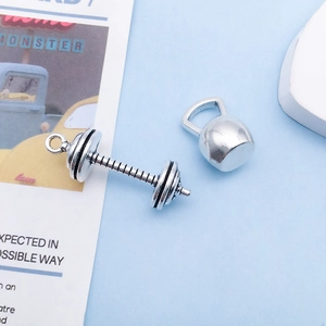Makroaufnahme von Hantel- und Kettlebell-Anhängern aus Silber für DIY-Schmuck